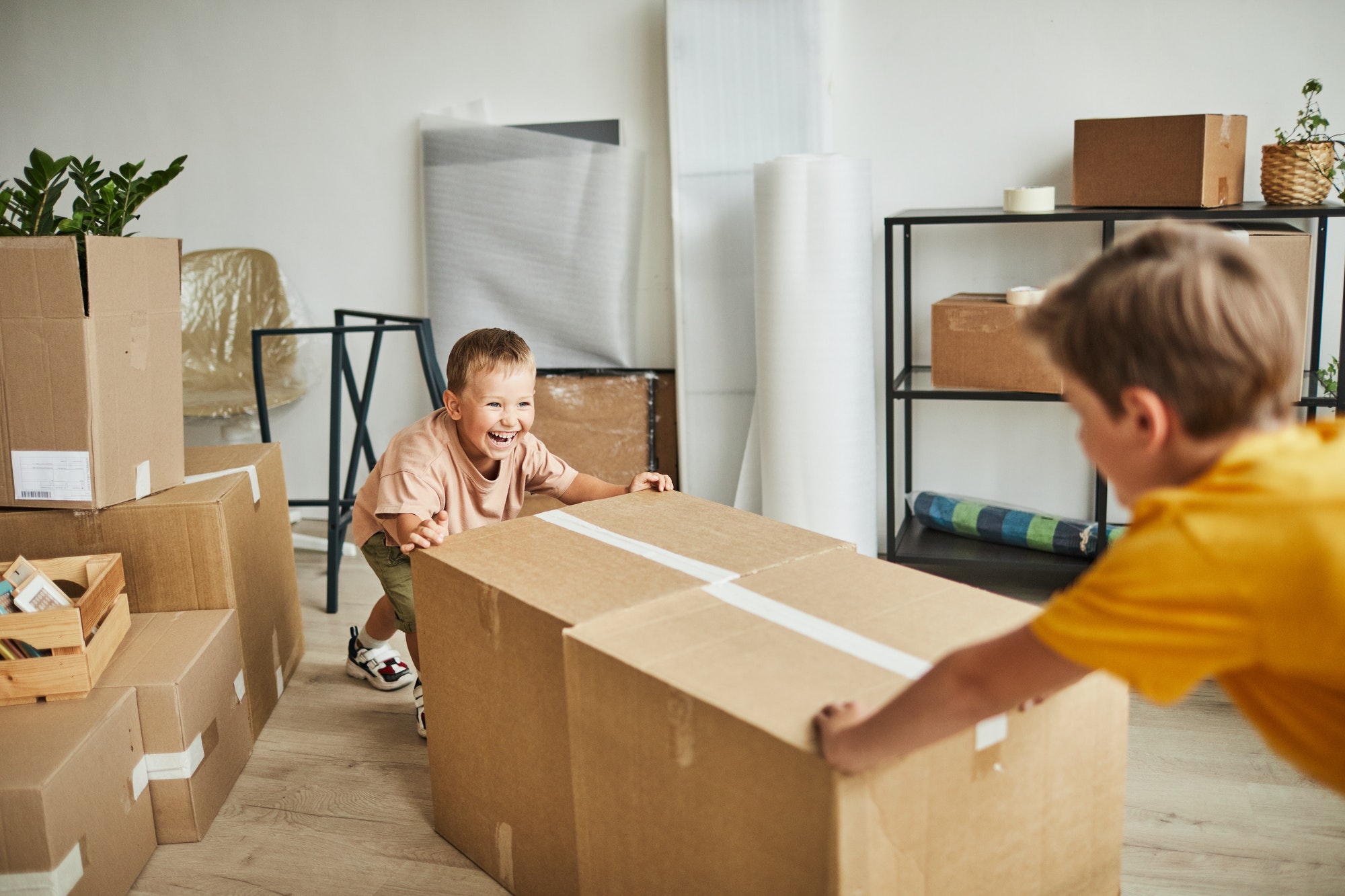 Two Boys Moving Boxes in New House